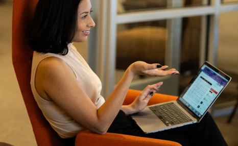 Woman discussing a project while working on a laptop